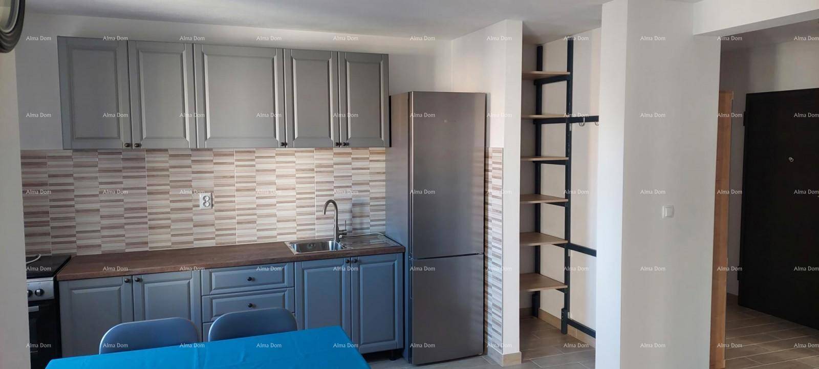 Moderne Küche mit grauen Schränken, Spüle, Kühlschrank und offenem Regal im Hintergrund.