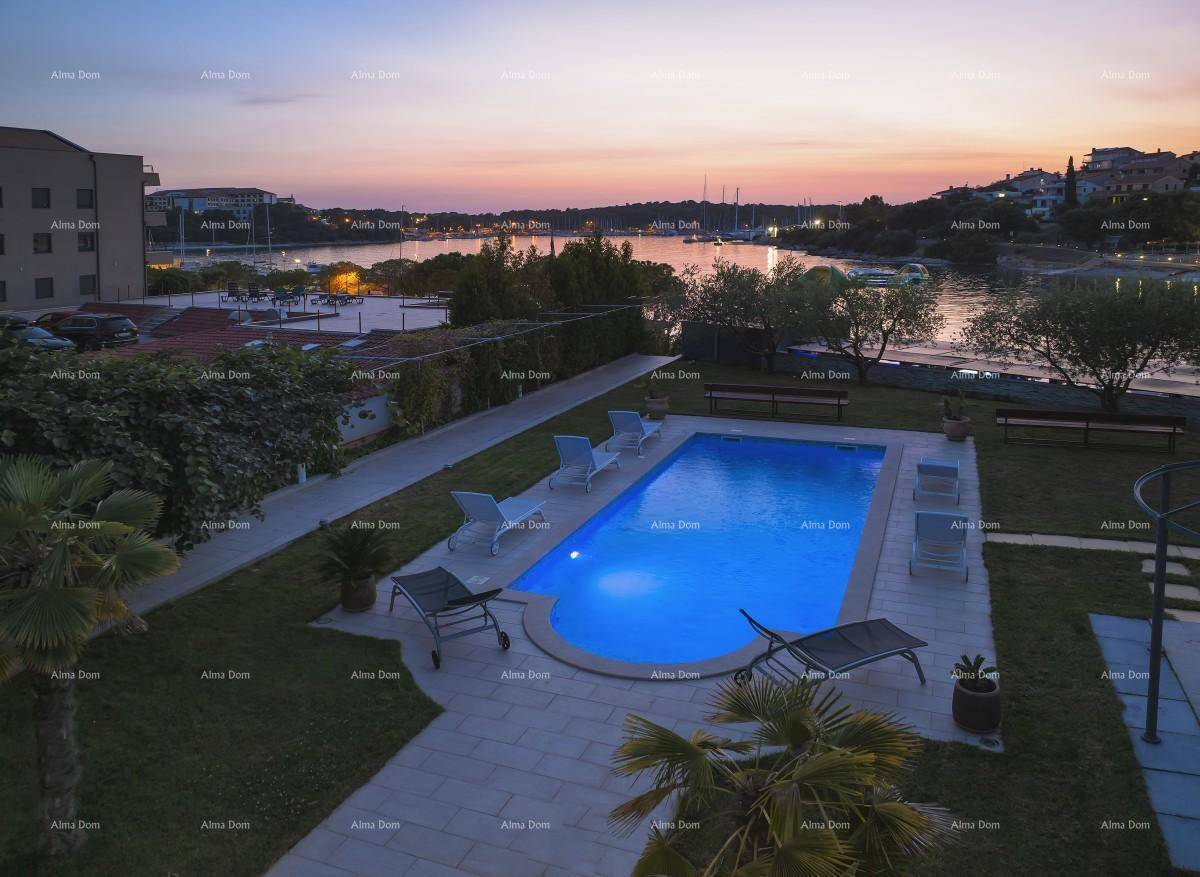 Beleuchteter Poolbereich im Garten bei Sonnenuntergang mit Blick auf die Bucht.