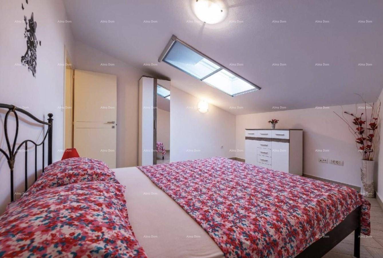 Schlafzimmer im Dachgeschoss mit Dachfenster, Doppelbett und Kommode.
