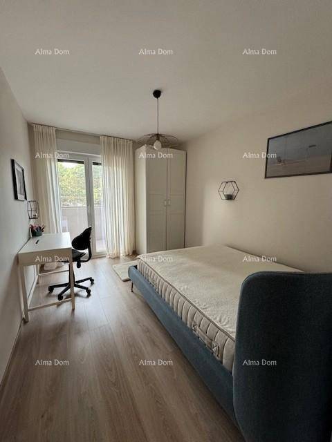Helles Schlafzimmer mit Holzboden, Schreibtisch und Zugang zum Balkon.