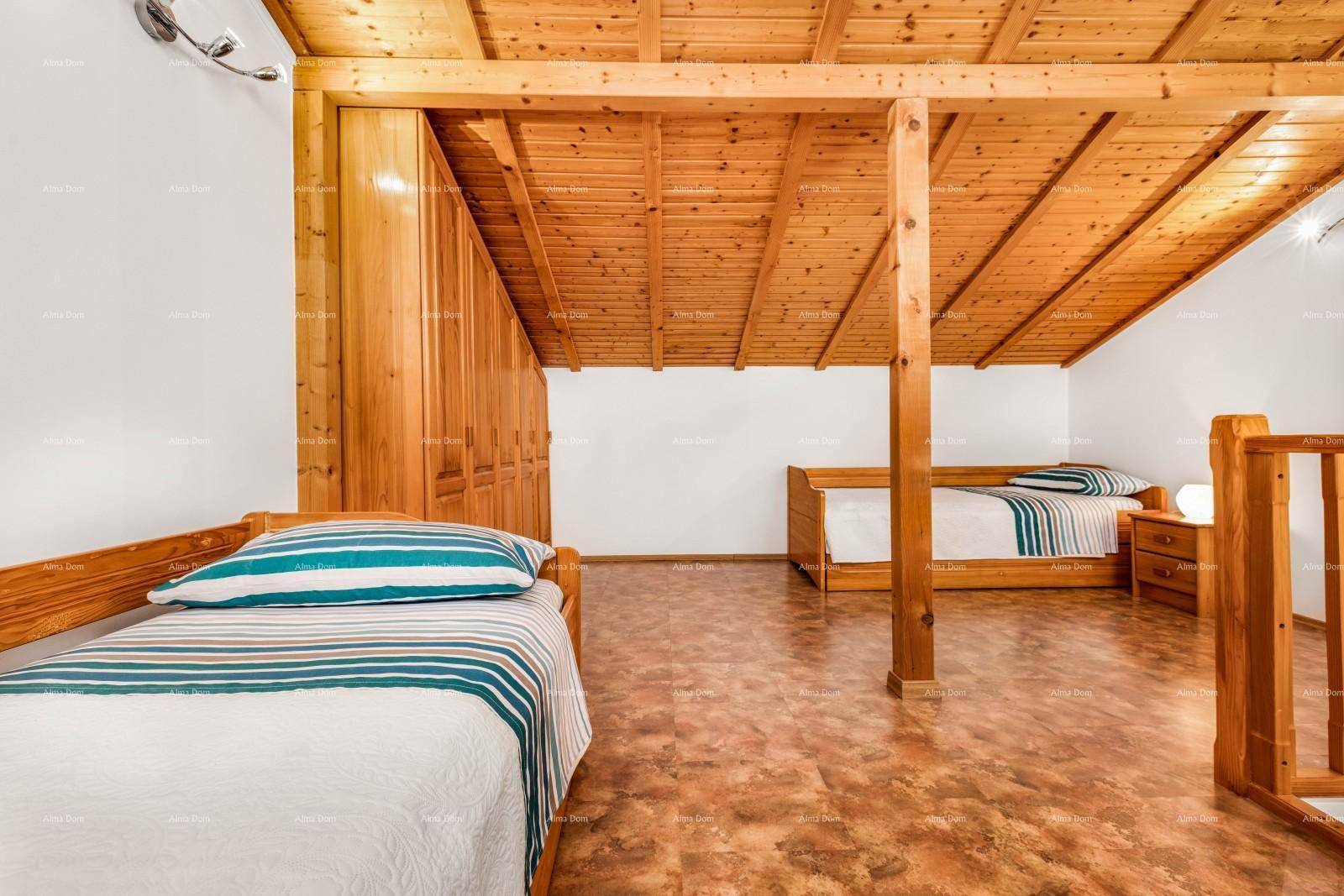 Gemütliches Dachschlafzimmer mit Holzbalken, zwei Einzelbetten und viel Stauraum.