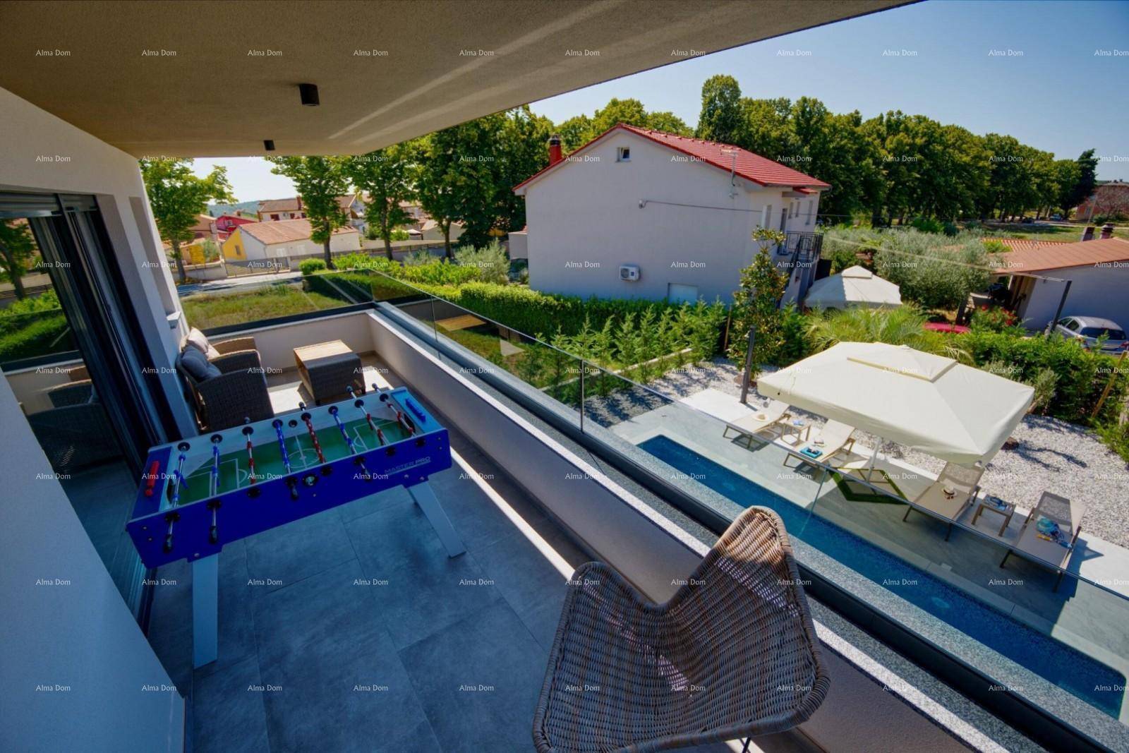 Geräumiger Balkon mit Tischfußball, Sitzgelegenheiten und Blick auf den Poolbereich und die Umgebung.
