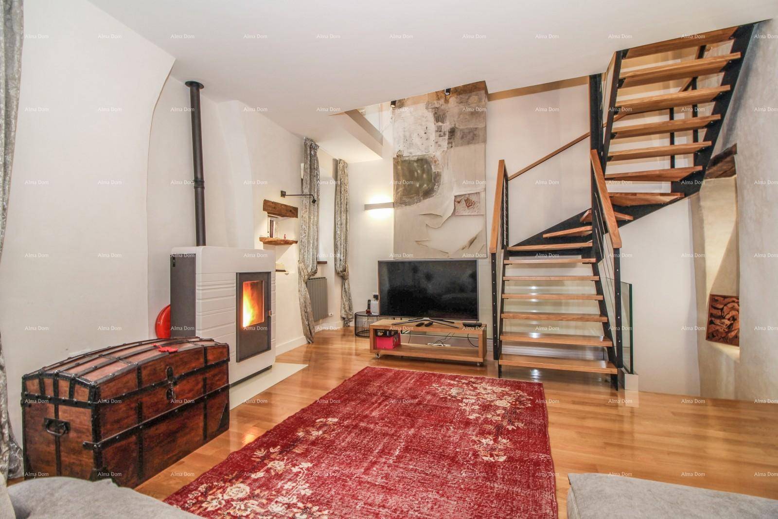 Wohnzimmer mit Kaminofen, Holzboden und einer modernen Treppe, die den Raum optisch erweitert.