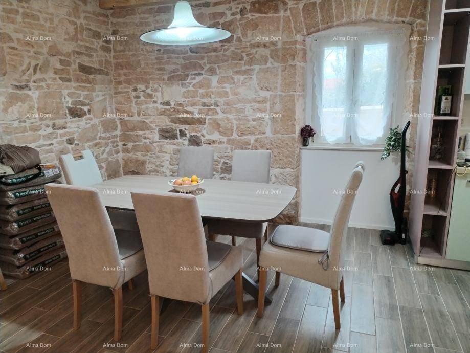 Heller Essbereich mit Steinwänden, großem Holztisch und bequemen Stühlen, ideal für gemeinsame Mahlzeiten.