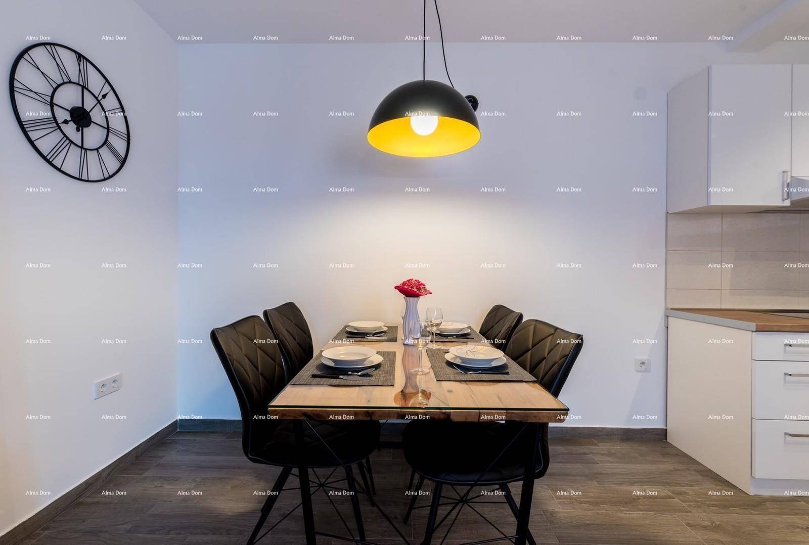 Gemütlicher Essbereich mit modernem Tisch und Stühlen, beleuchtet von einer stilvollen Pendelleuchte.