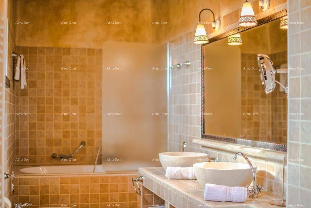 Badezimmer mit Badewanne, zwei Aufsatzwaschbecken und traditionellen Fliesen.