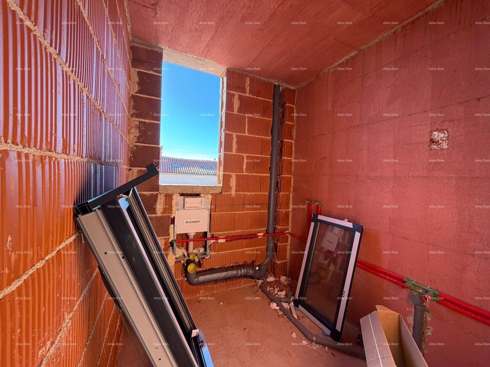 Innenraum im Rohbau mit sichtbaren Wasserleitungen und einem Fensterrahmen.