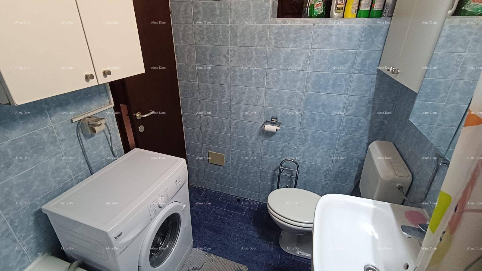 Badezimmer mit blauen Fliesen, Toilette, Waschbecken und Waschmaschine.
