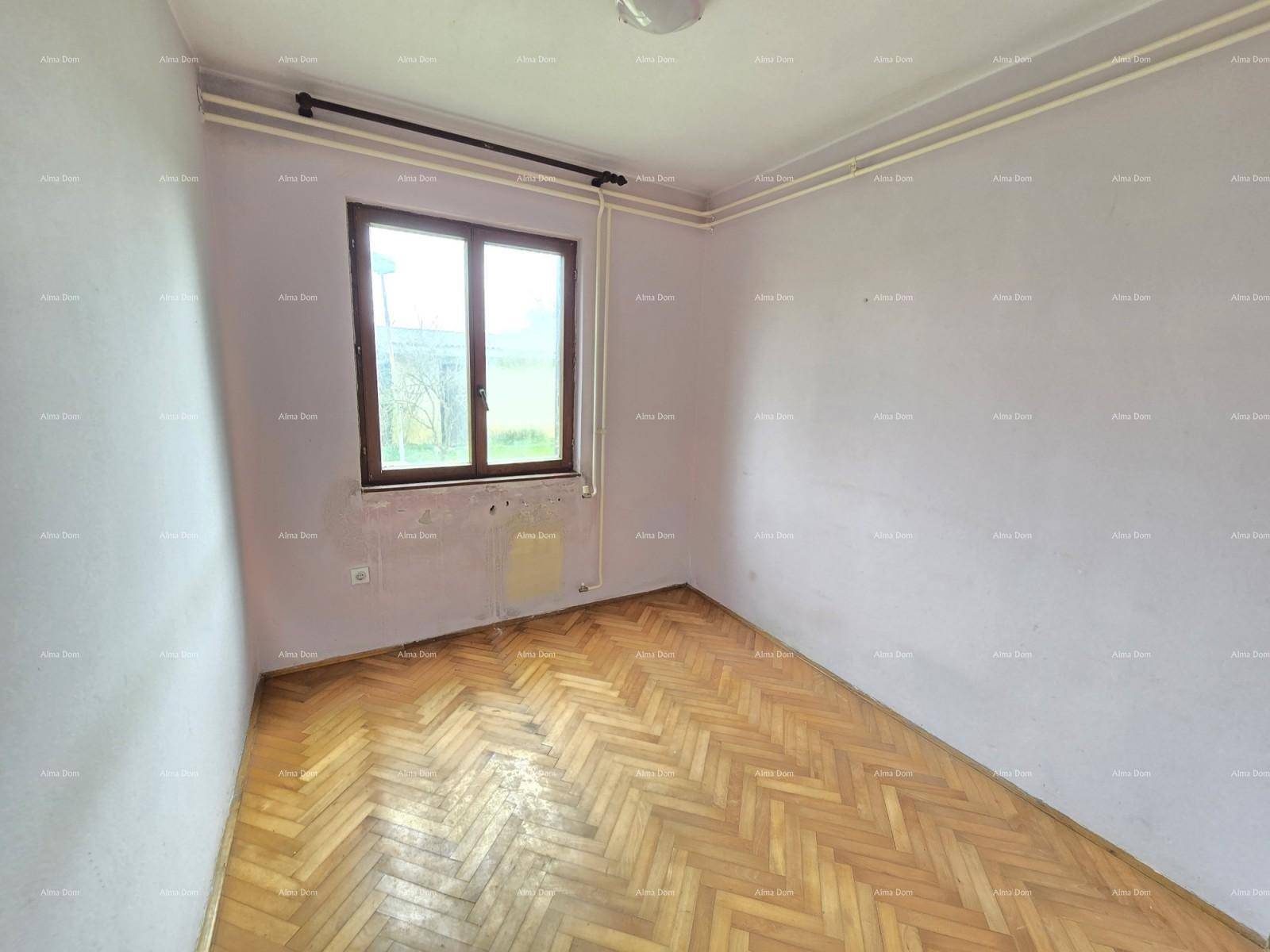 Schlafzimmer mit Fischgrätparkett und einem Fenster, das auf eine Renovierung wartet und viel Licht hereinlässt.