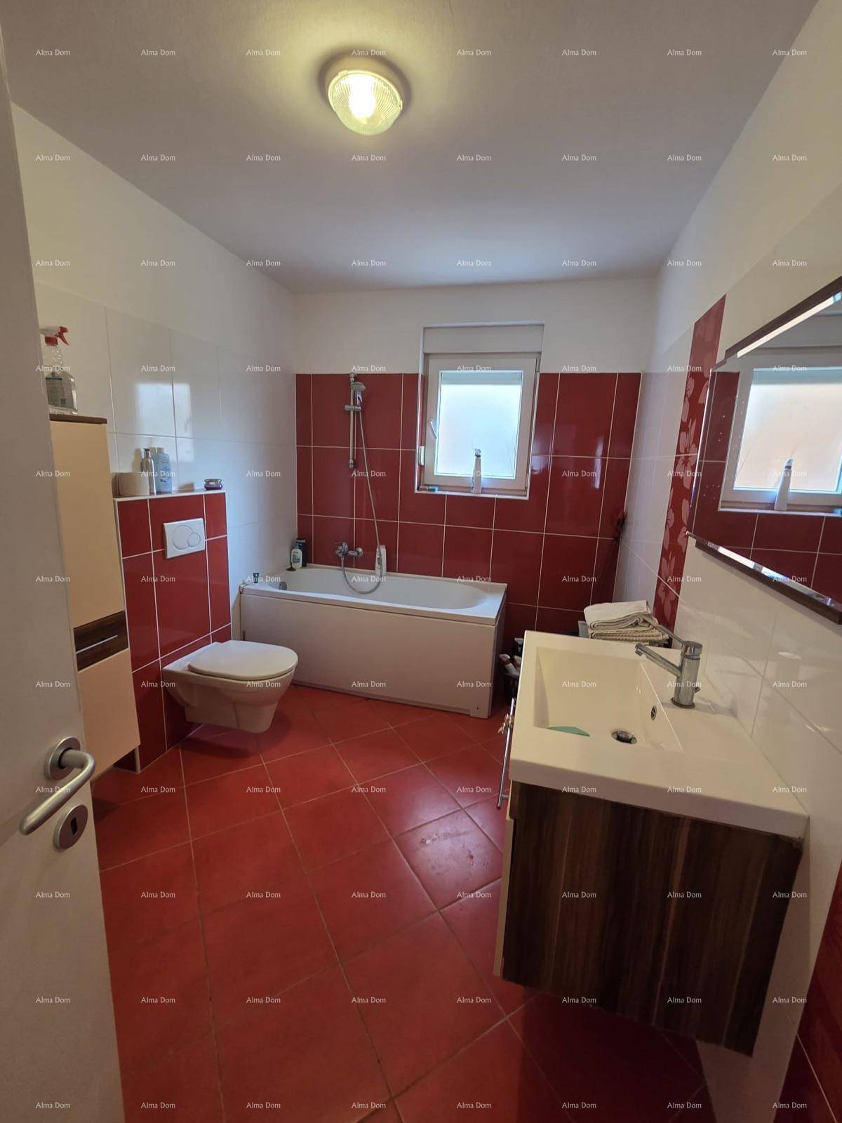 Badezimmer mit Badewanne, Wand-WC und modernem Waschtisch, alles in roten und weißen Fliesen.