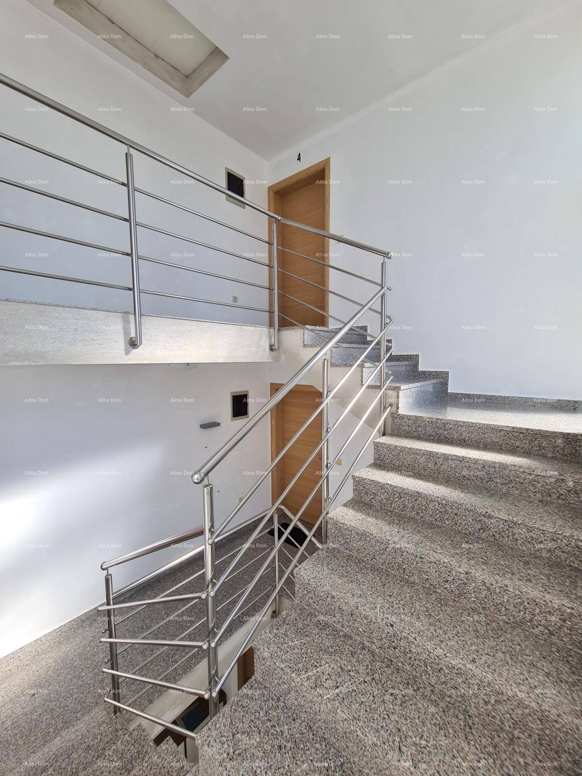 Helles Treppenhaus mit Granitstufen und Edelstahlgeländer, verbindet die Etagen.