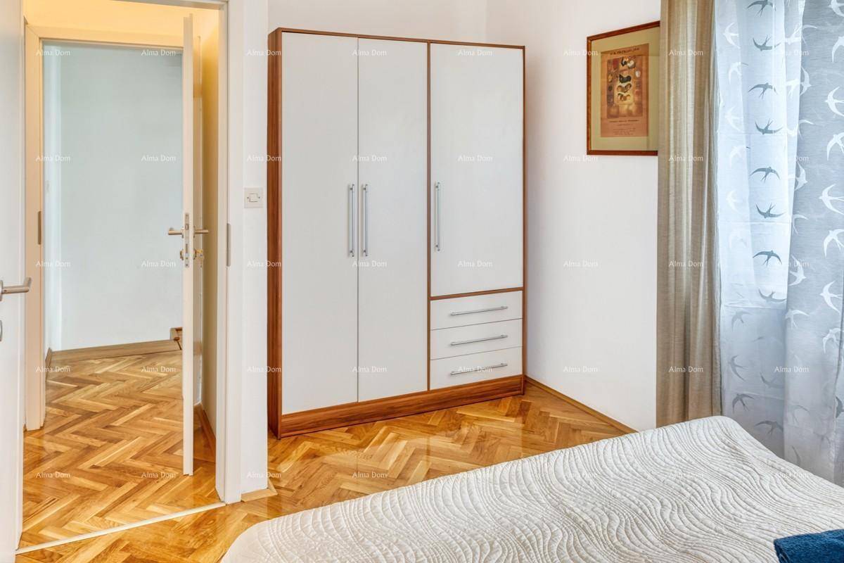 Schlafzimmer mit modernem Kleiderschrank und Blick in den angrenzenden Flur mit Parkettboden.