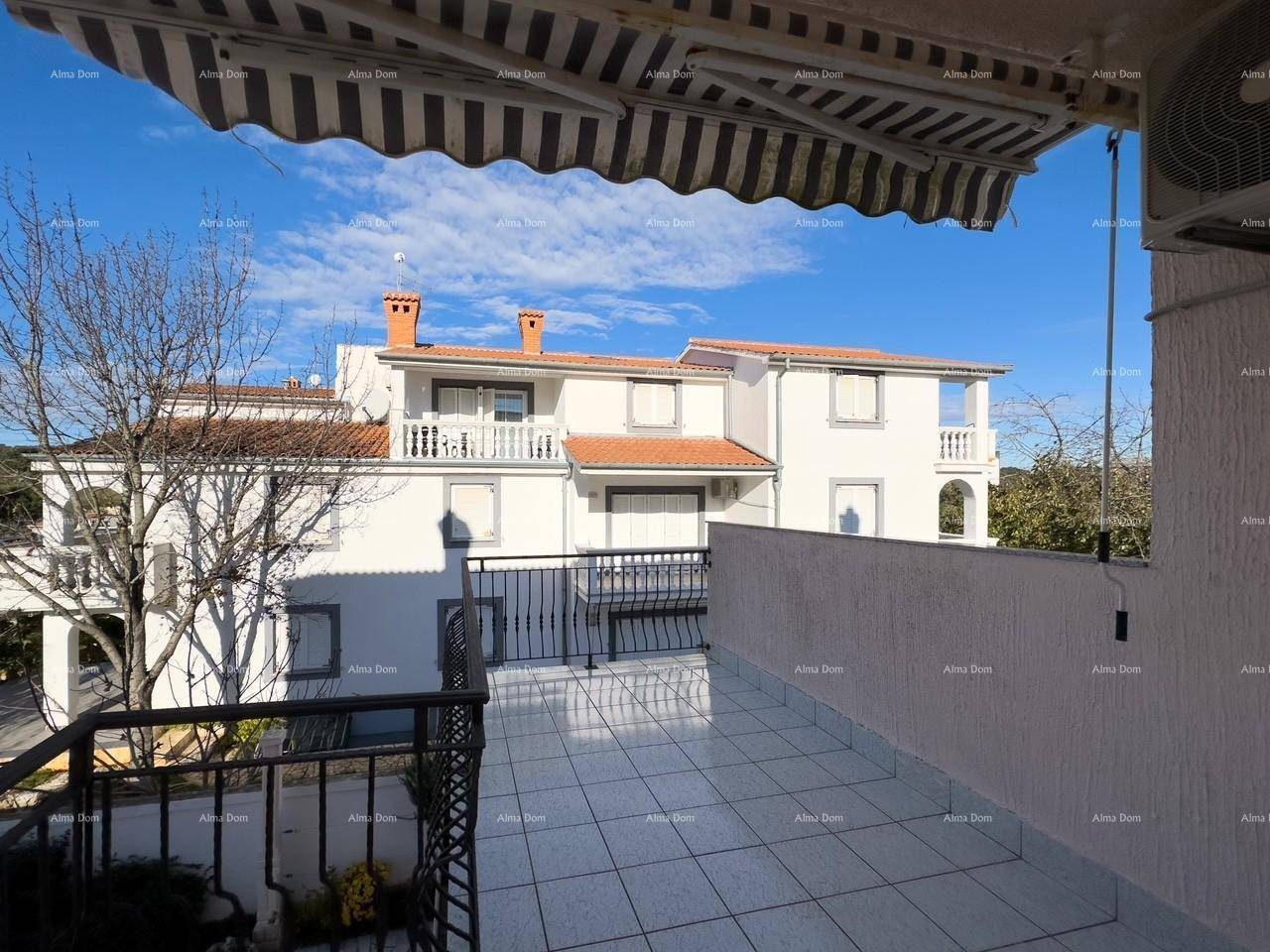 Großer gefliester Balkon mit Markise und Blick auf benachbarte Gebäude und die Umgebung.