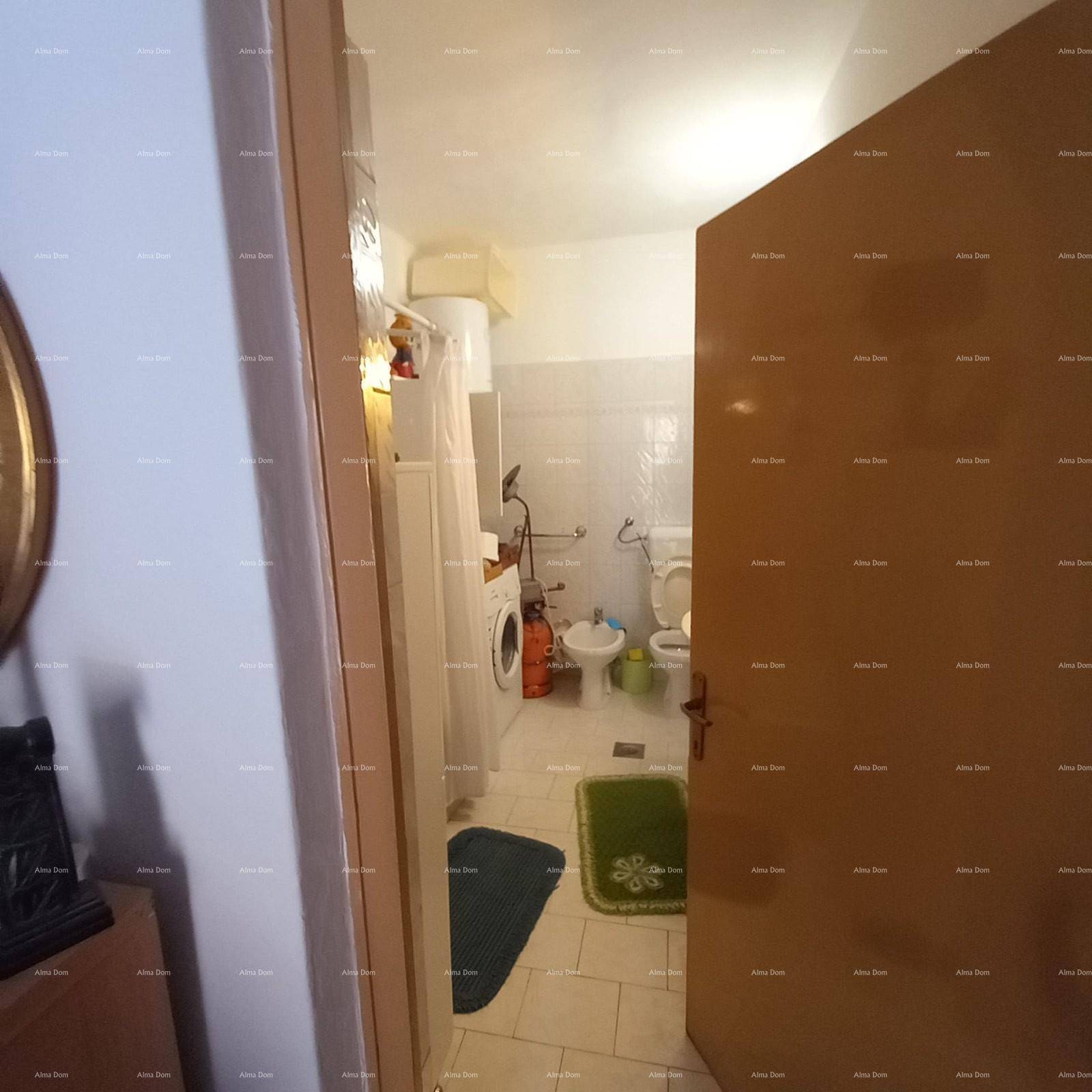 Badezimmer mit Fliesenboden, Toilette, Bidet und Waschmaschine.