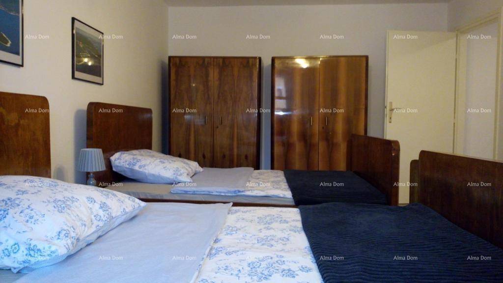 Geräumiges Schlafzimmer mit drei Einzelbetten und zwei großen Holzschränken.