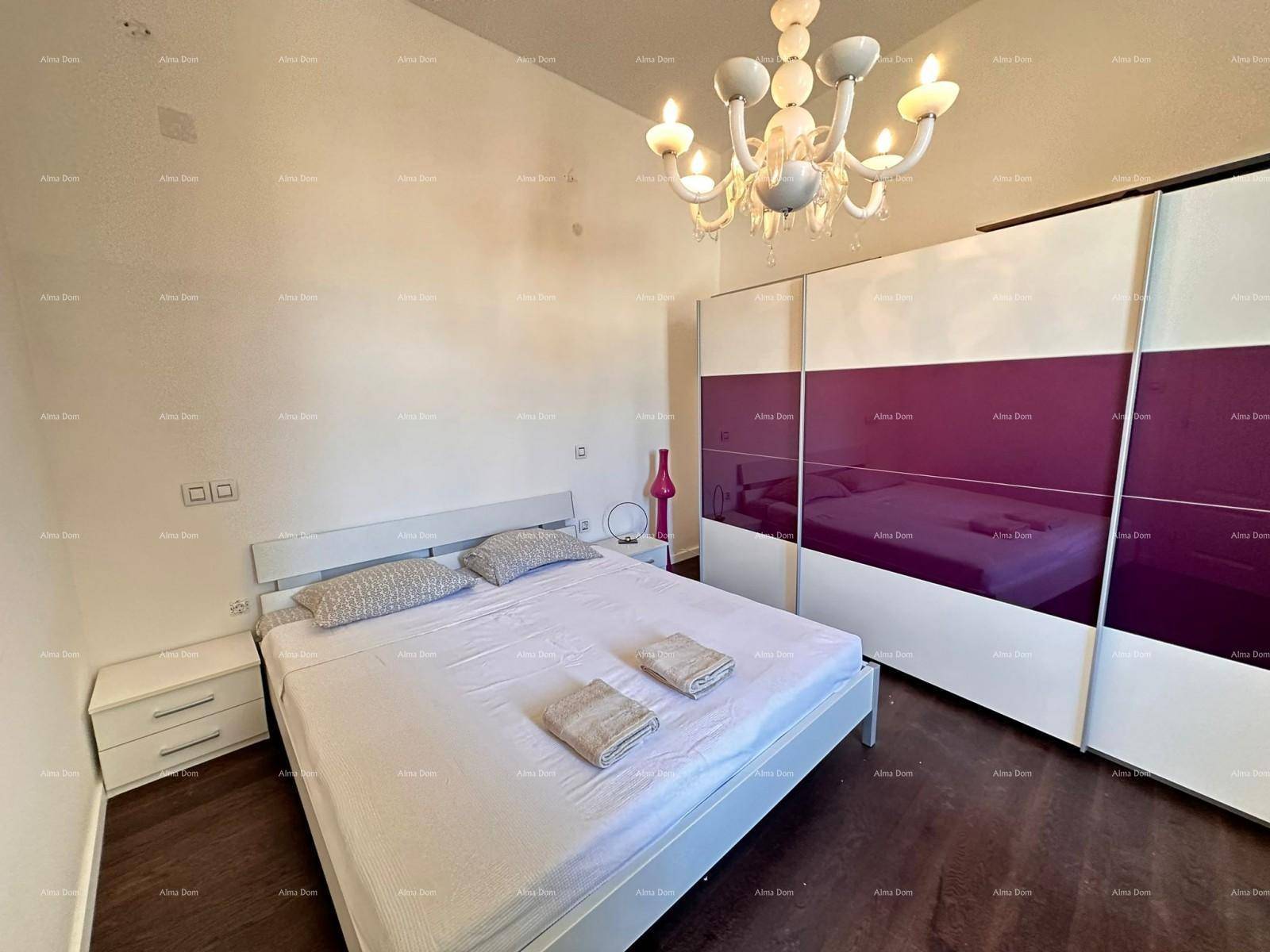 Modernes Schlafzimmer mit Doppelbett, lila Schiebetürenschrank und einem eleganten Kronleuchter.