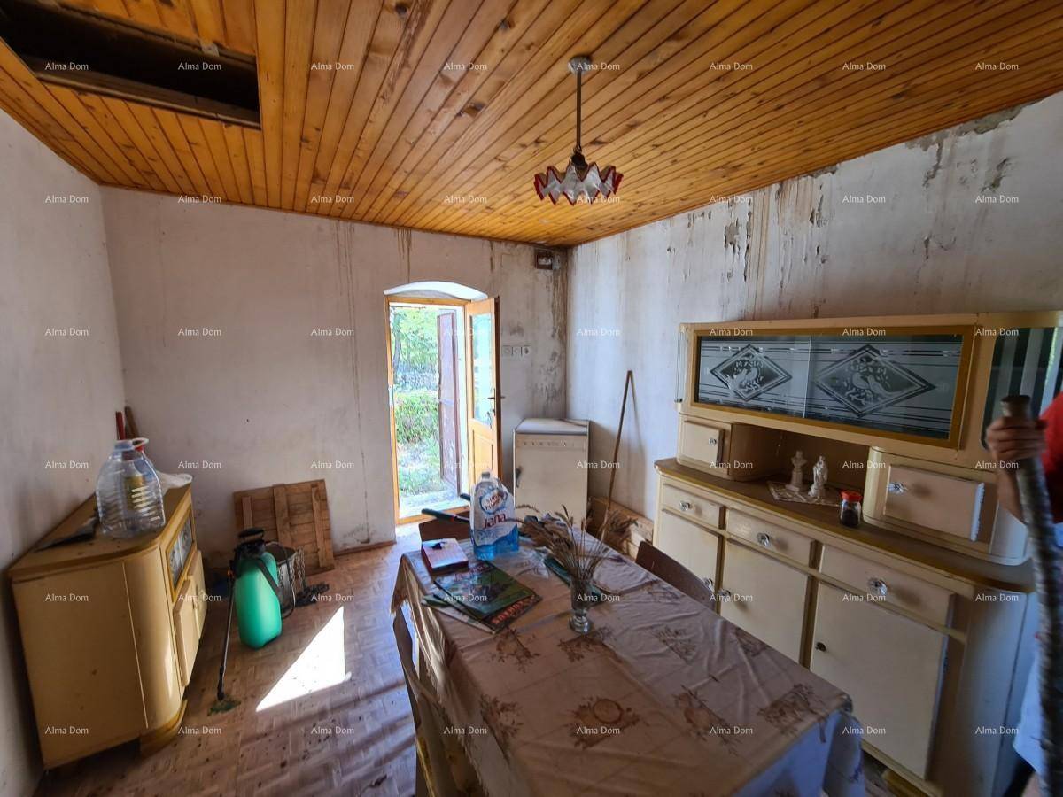 Rustikaler Essbereich mit Holztisch, Schrank und Zugang zum Außenbereich, unter einer Holzdecke.