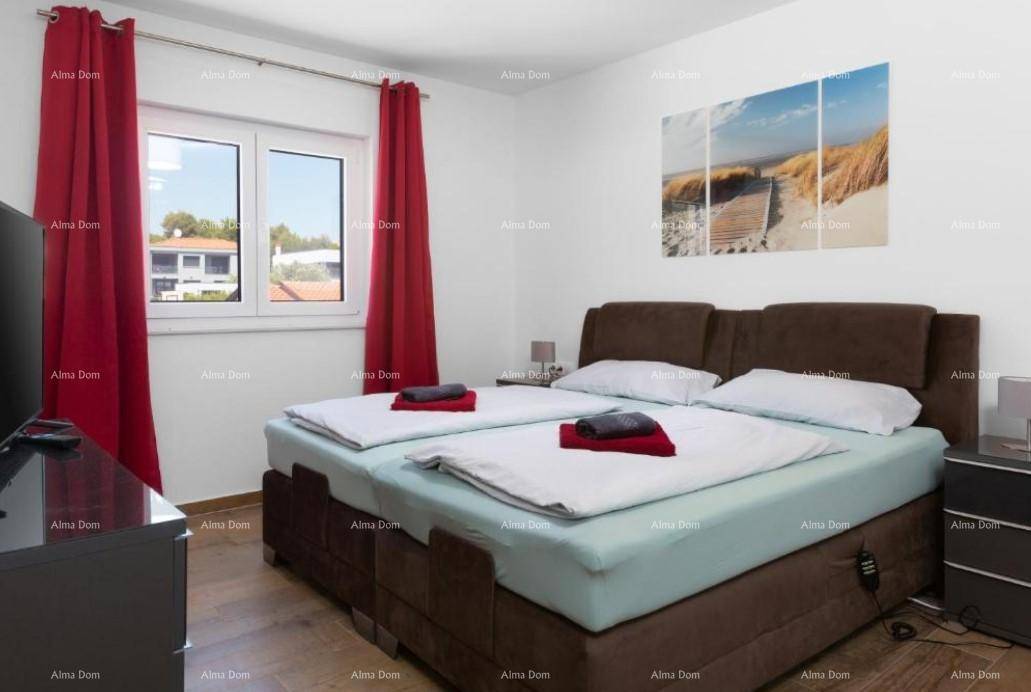 Gemütliches Schlafzimmer mit großem Doppelbett, roten Vorhängen und hellem Fenster.