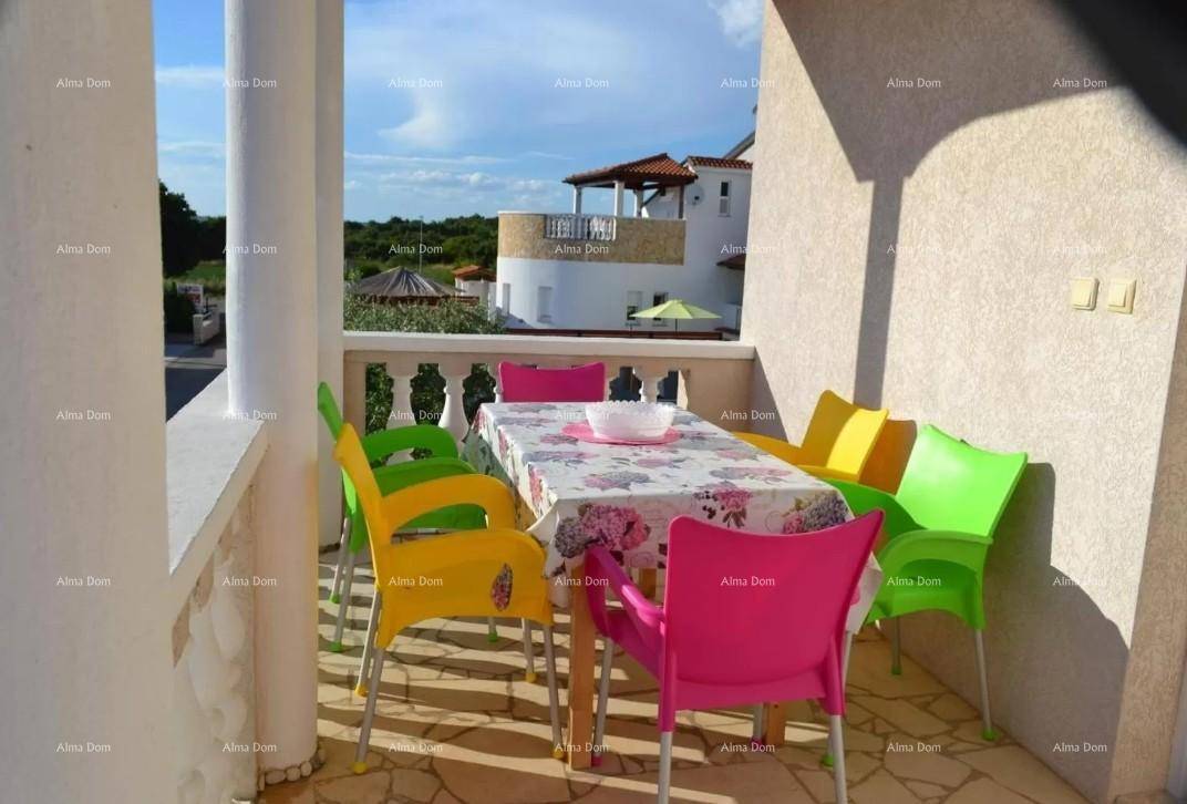 Heller Balkon mit bunten Gartenmöbeln und Blick auf die Umgebung.