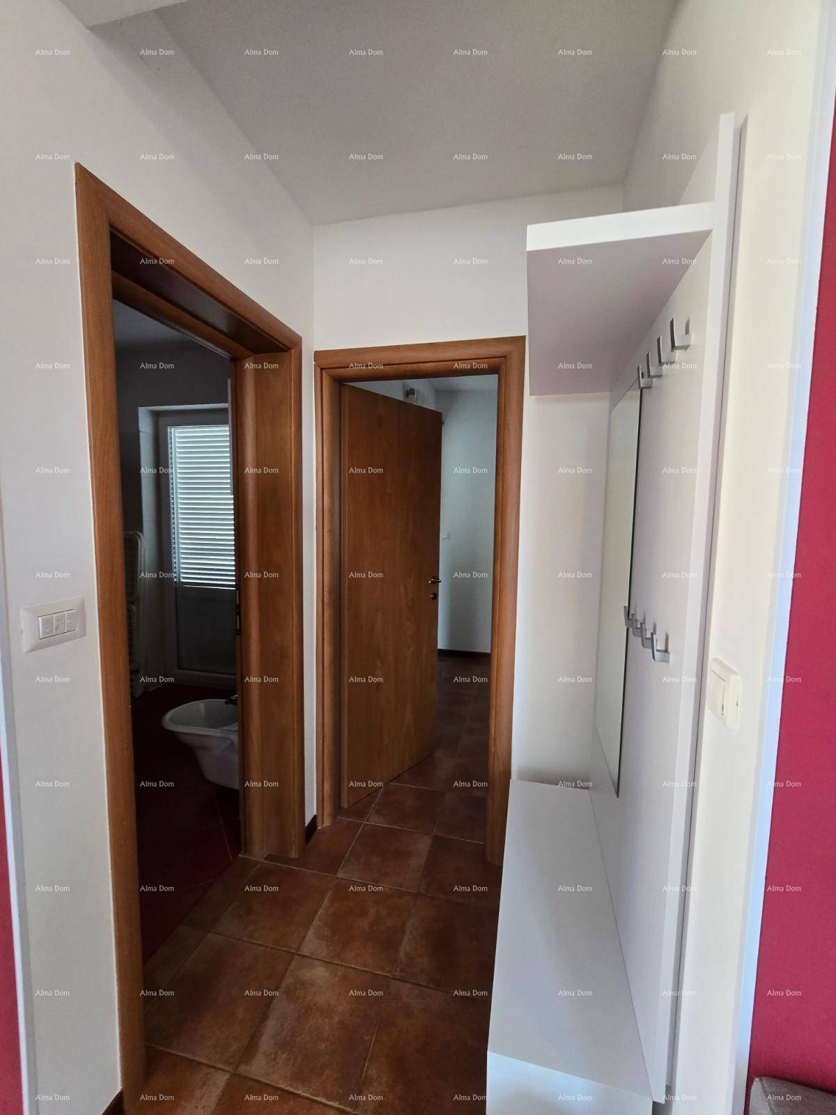Heller Flur mit Fliesenboden, Holztüren und einer Garderobe.