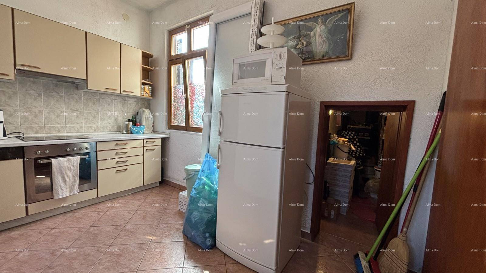 Helle Küche mit Kühlschrank, Mikrowelle und einem Fenster, das Tageslicht hereinlässt.