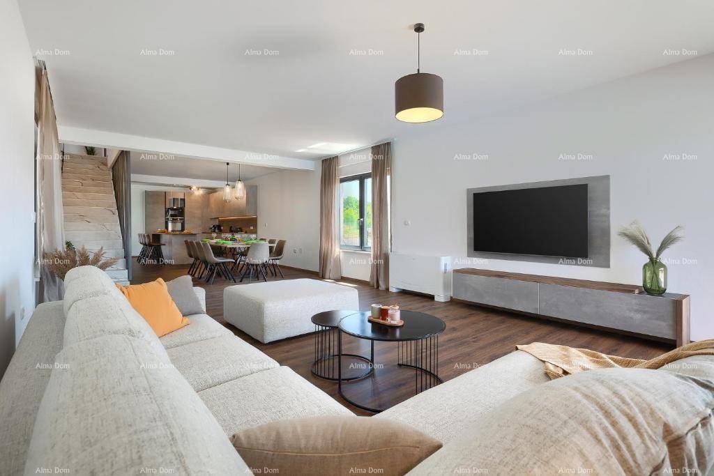 Offener Wohn- und Essbereich mit modernem Sofa, Holzboden und Blick auf den Essbereich und die Küche.