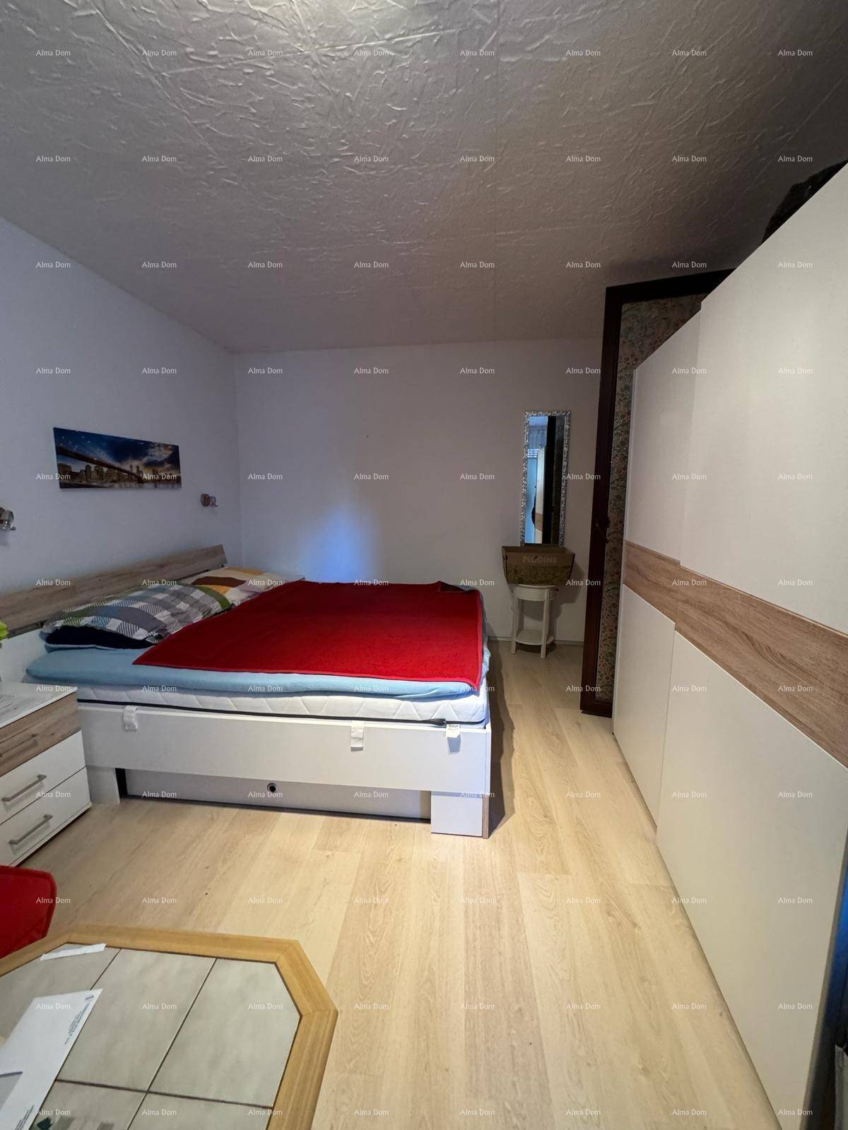 Schlafzimmer mit Doppelbett, Nachttischen und einem großen Kleiderschrank mit Spiegelfront.