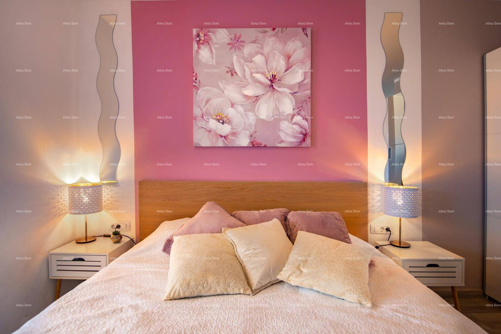 Helles Schlafzimmer mit rosa Akzentwand, Doppelbett und Nachttischen.