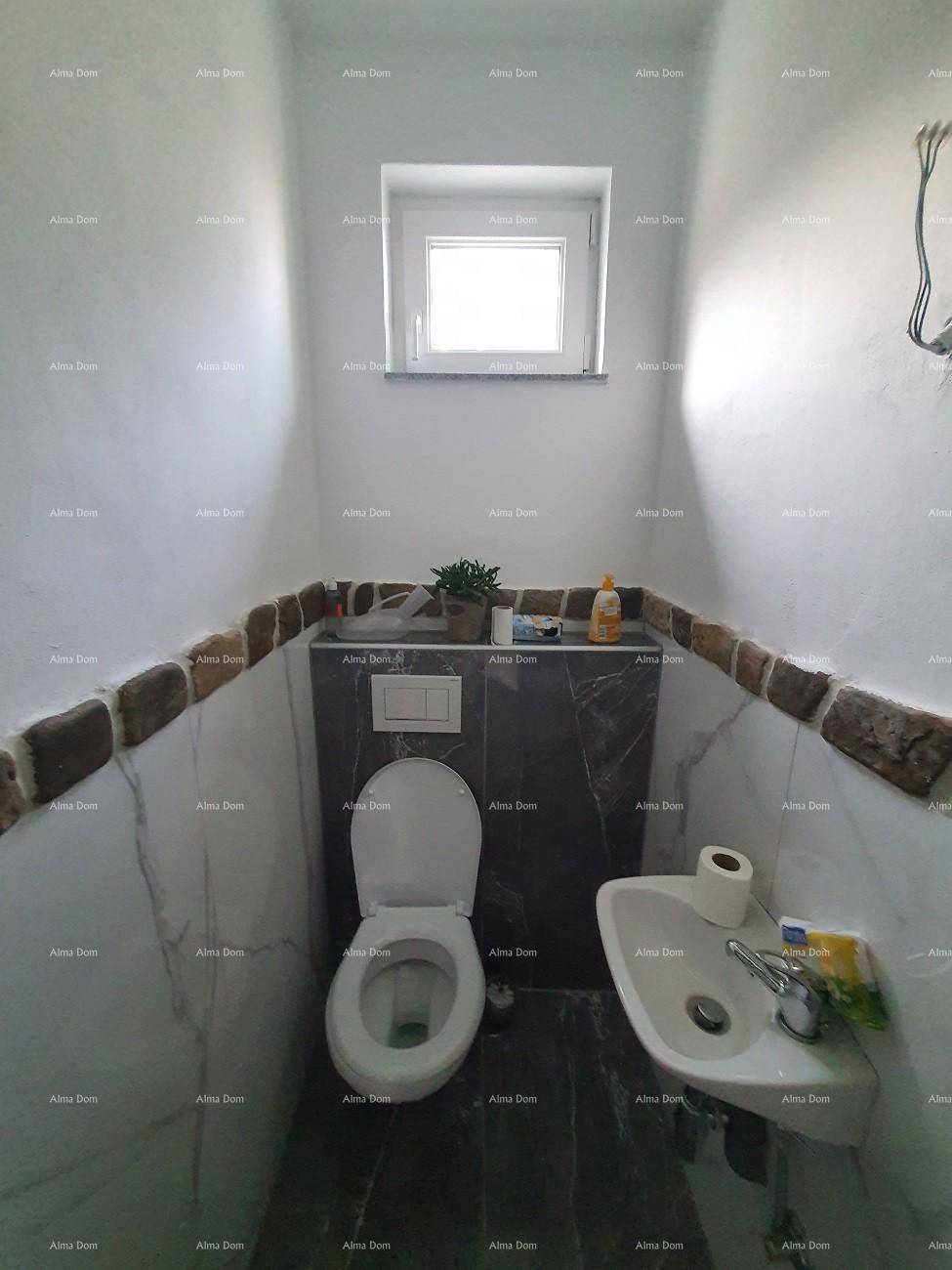 Kleines Gäste-WC mit wandmontierter Toilette, Waschbecken und einem Fenster.