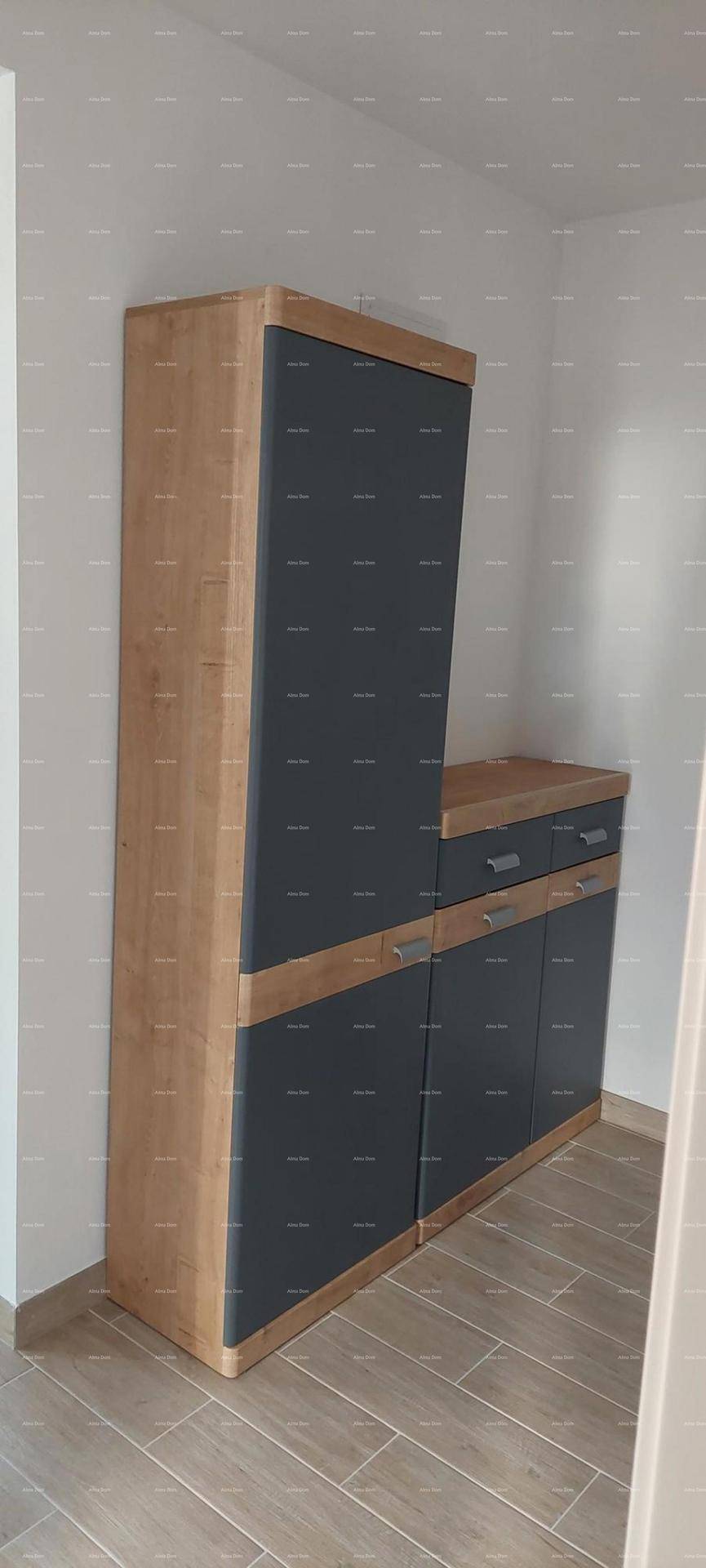 Moderner Schrank in Holz- und Anthrazit-Optik im Flurbereich für Stauraum.