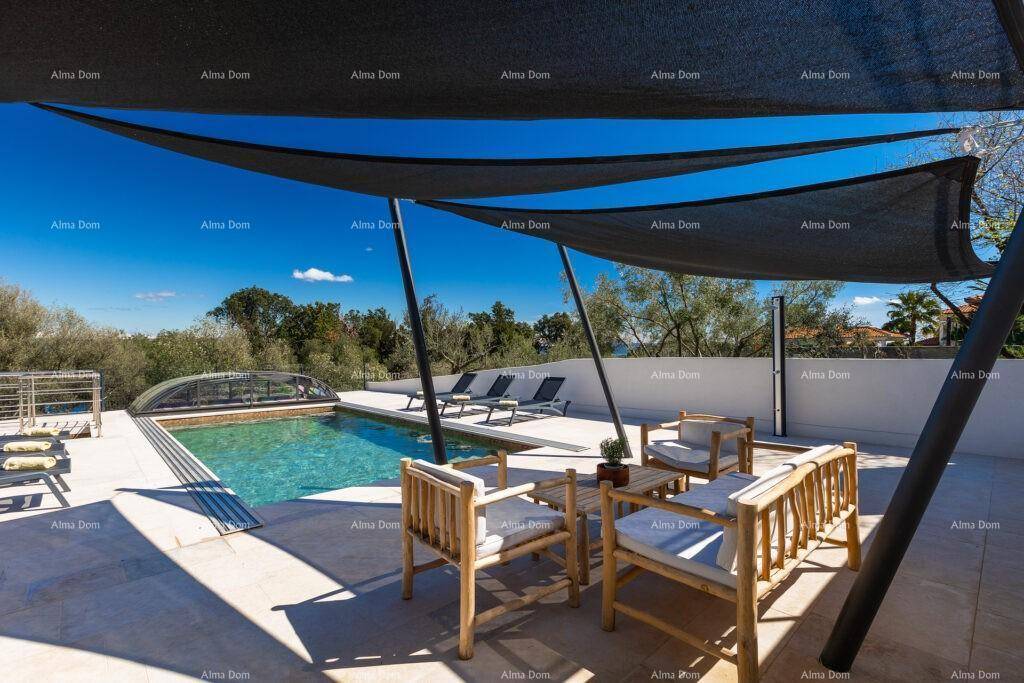Große Terrasse mit Lounge-Möbeln, Sonnensegel und Blick auf den Poolbereich.