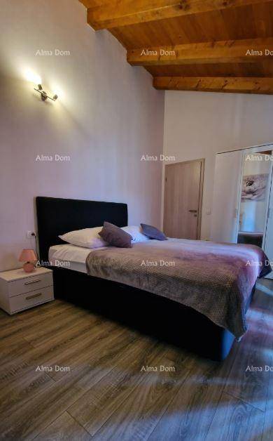 Gemütliches Schlafzimmer mit Holzbalkendecke, Laminatboden und modernem Doppelbett.