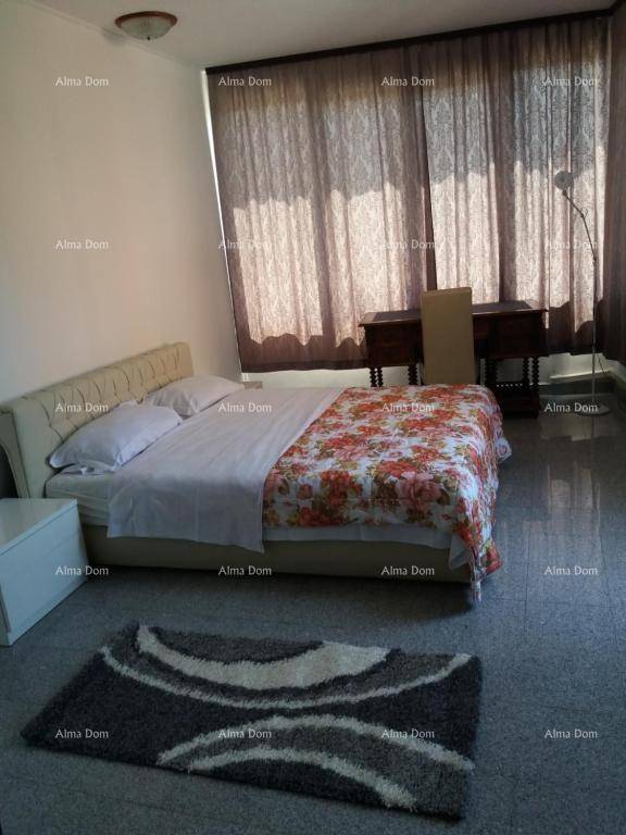 Schlafzimmer mit großem Bett, gemustertem Teppich und dunklen Vorhängen für Privatsphäre.