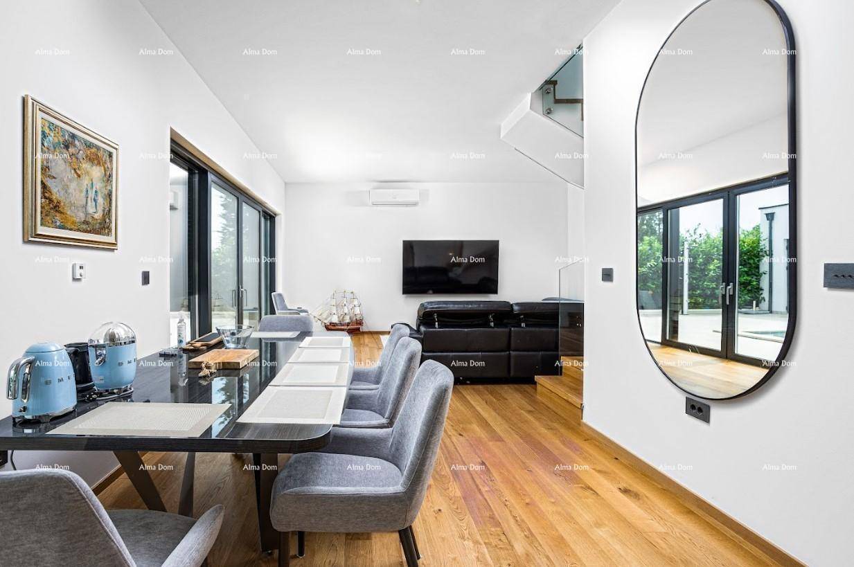 Offener Wohn- und Essbereich mit Holzboden, modernem Esstisch und Zugang zur Terrasse.
