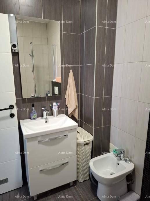 Badezimmer mit modernem Waschtisch, Spiegel und einem Bidet.