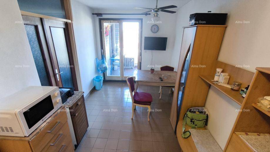 Esszimmer mit Deckenventilator, Esstisch und Zugang zu einem Außenbereich.