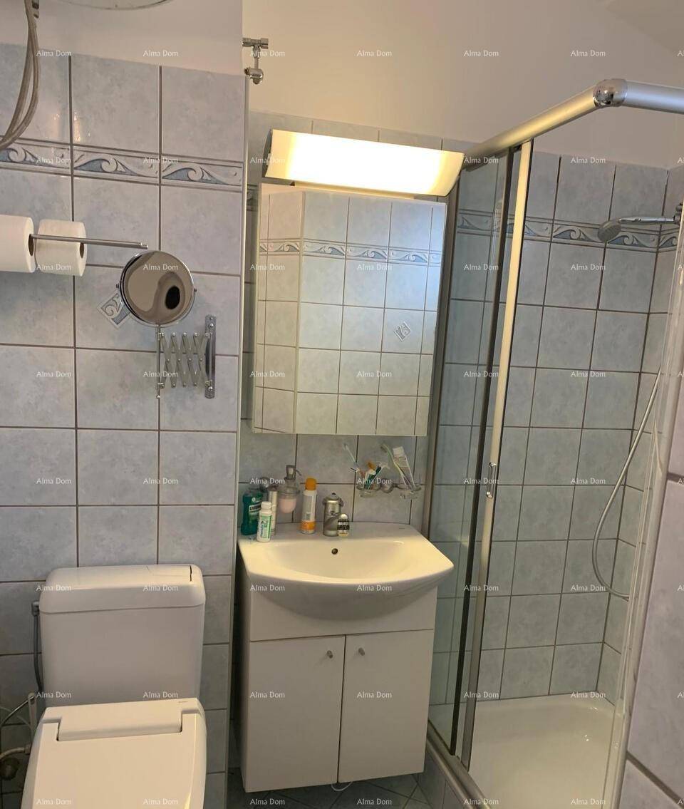 Funktionales Badezimmer mit Dusche, WC und Waschbecken, ausgestattet mit hellblauen Fliesen und einem Spiegelschrank.