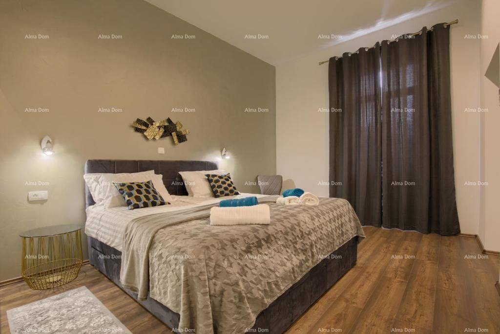 Komfortables Schlafzimmer mit großem Doppelbett, Holzboden und dunklen Vorhängen.