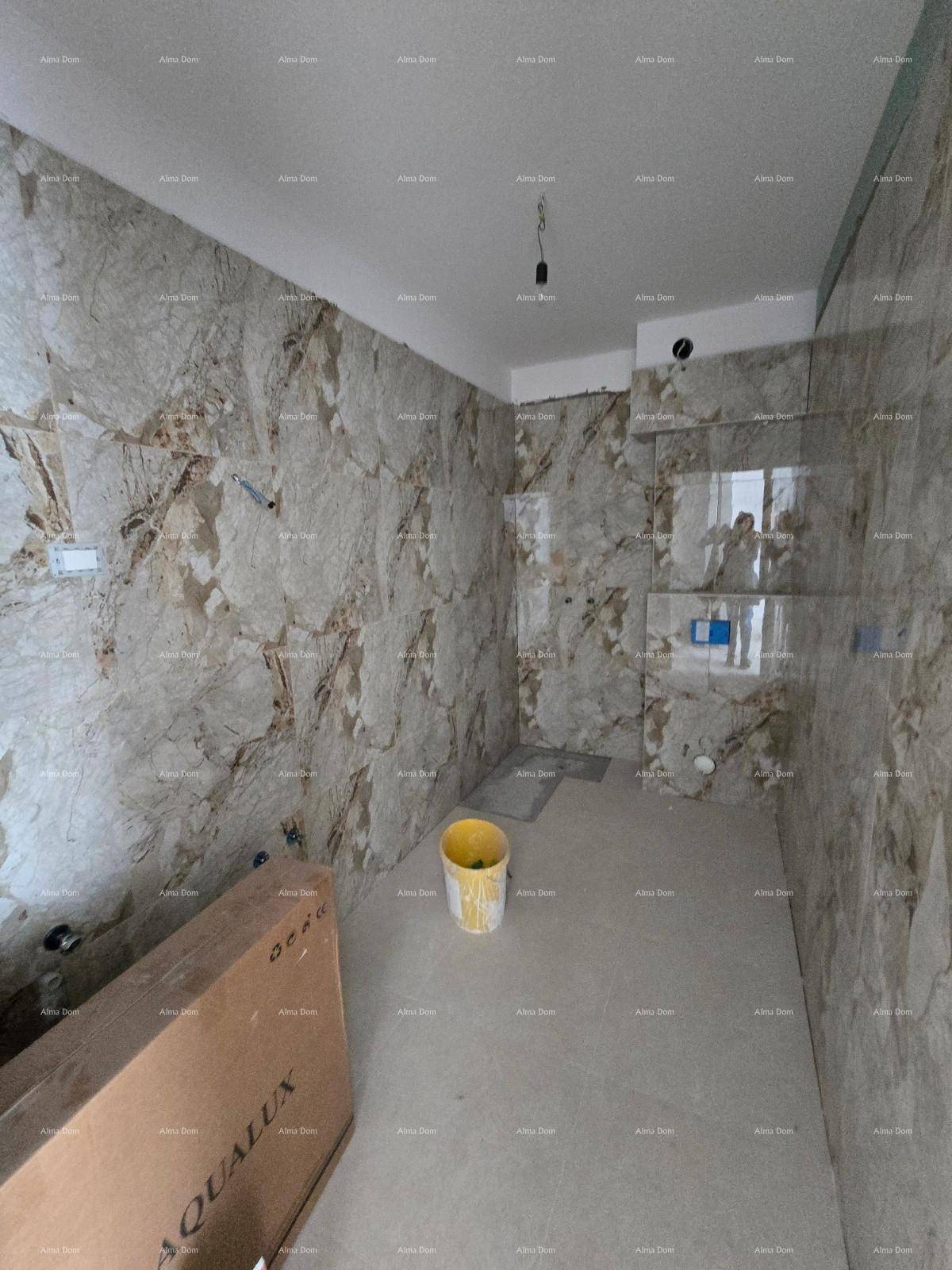 Unfertiges Badezimmer mit modernen Marmorfliesen an den Wänden und Betonboden.