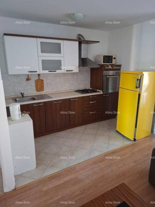 Funktionale Küche mit Holzunterschränken, weißen Oberschränken und einem auffälligen gelben Kühlschrank.