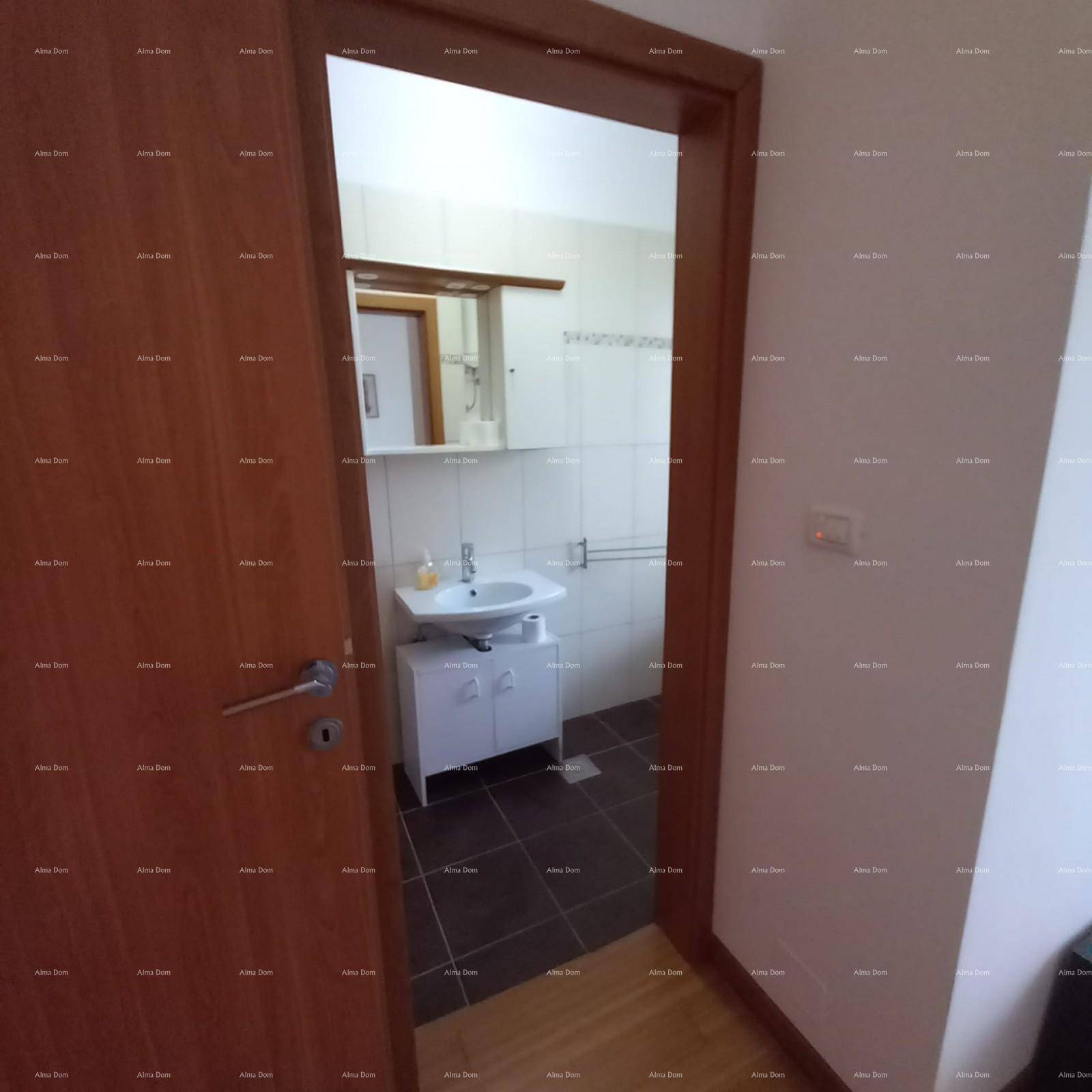 Eingang zu einem Badezimmer mit Waschbecken, Unterschrank und Spiegel, gefliest.
