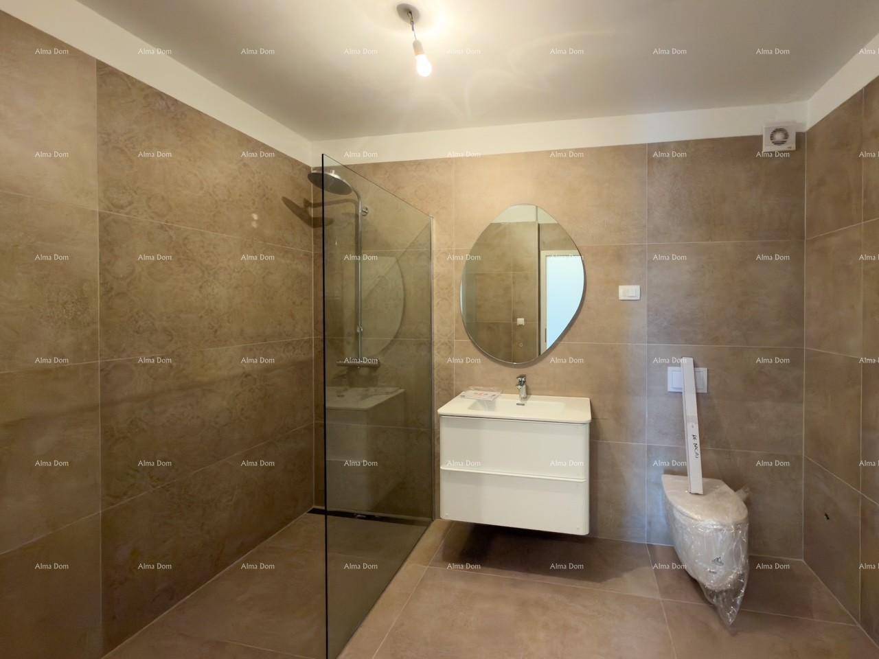 Modernes Badezimmer mit beigefarbenen Fliesen, begehbarer Dusche, Waschtisch und wandhängendem WC.