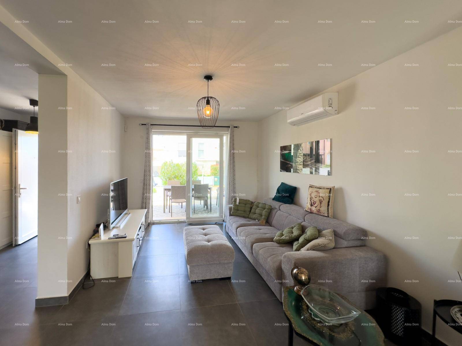Gemütliches Wohnzimmer mit großem Sofa, Klimaanlage und Schiebetür zum Außenbereich.