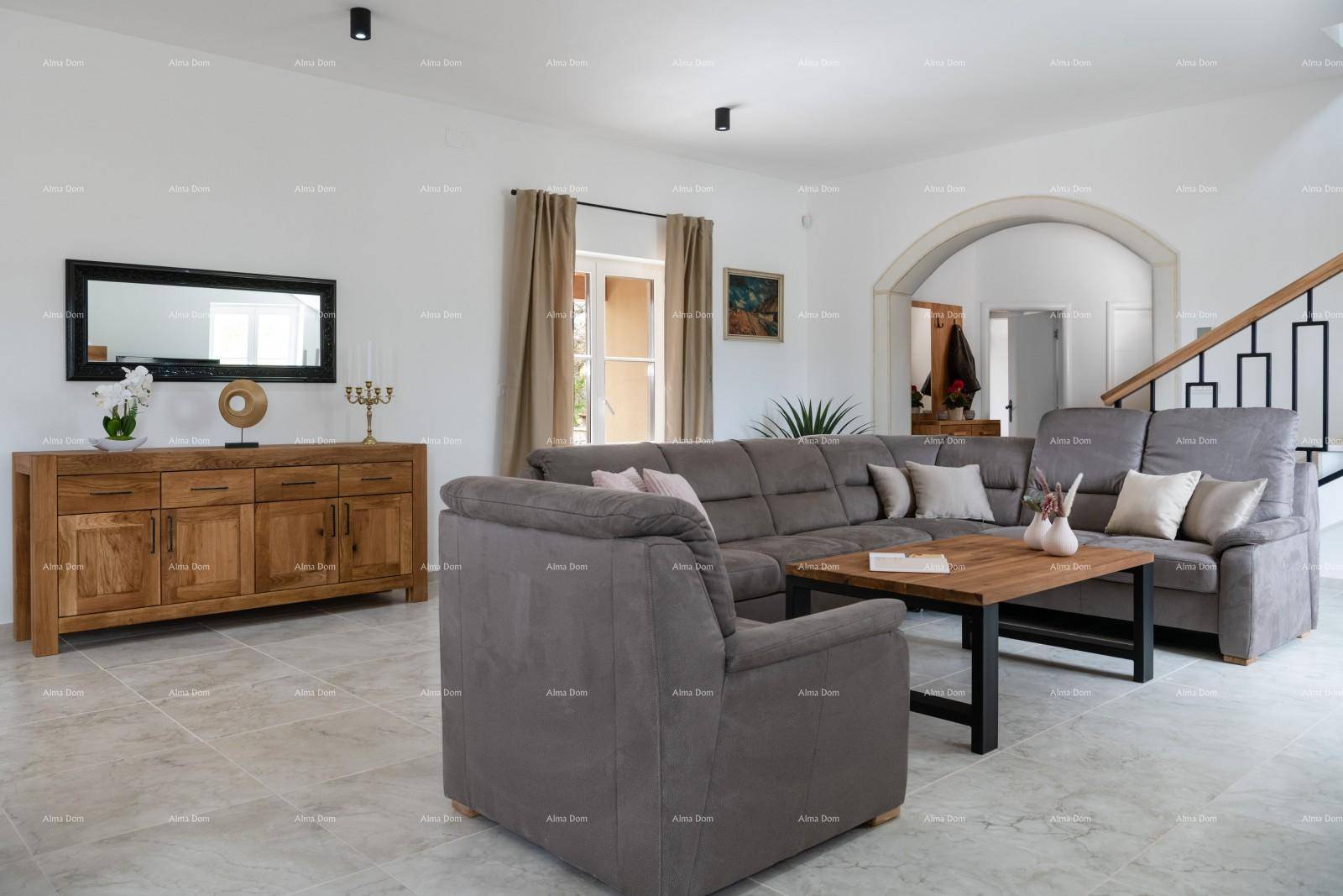 Geräumiges Wohnzimmer mit großem Ecksofa, Holzanrichte und Zugang zu anderen Bereichen.