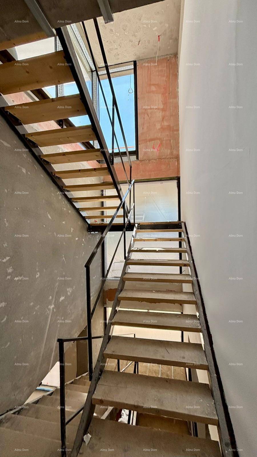 Treppenhaus im Rohbau mit Holzstufen und Metallgeländer, bereit für den weiteren Ausbau.