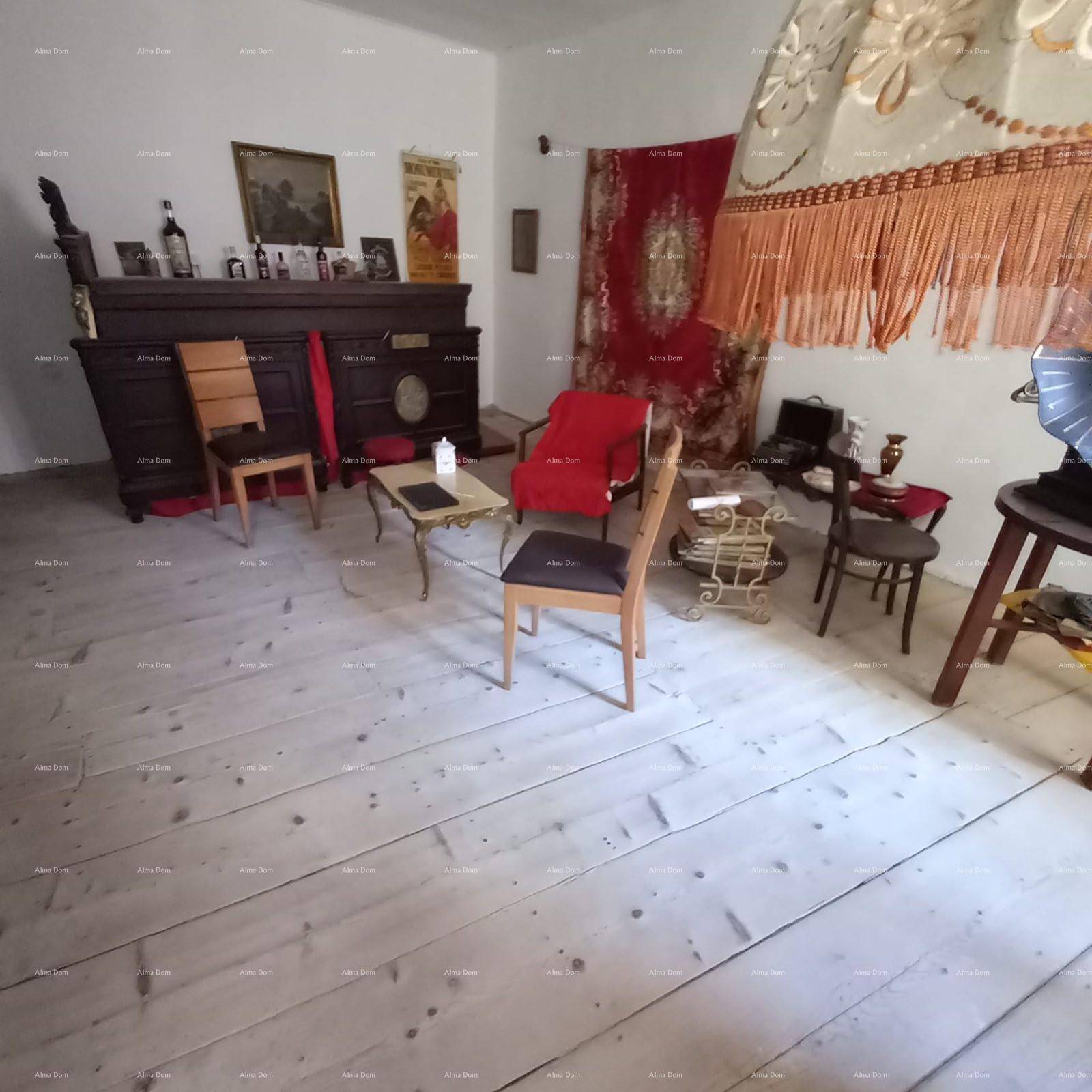 Geräumiges Wohnzimmer mit hellen Holzdielen, Vintage-Möbeln und dekorativen Textilien.