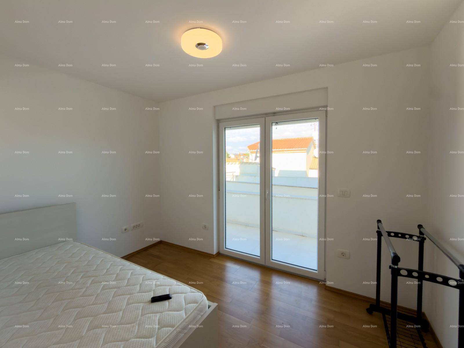 Helles Schlafzimmer mit Holzboden und großen Fenstern.