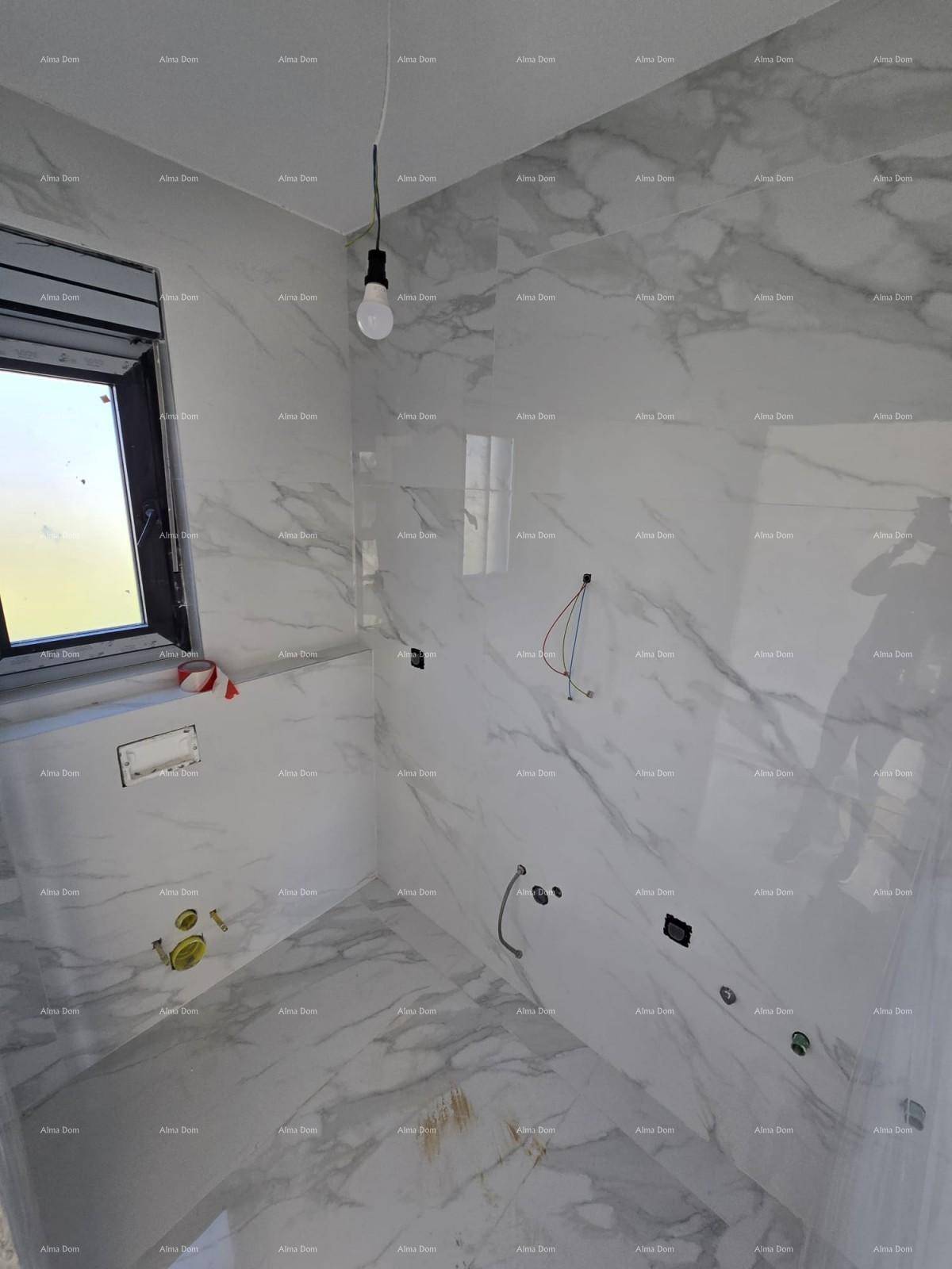 Modernes Badezimmer im Rohbau mit großformatigen Marmorfliesen und Fenster für Tageslicht.