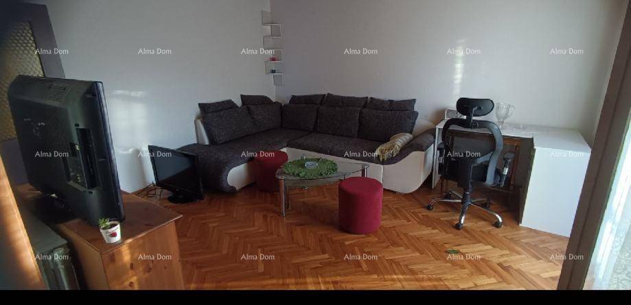 Gemütliches Wohnzimmer mit großem Ecksofa, Fernseher und einem Arbeitsbereich in der Ecke.