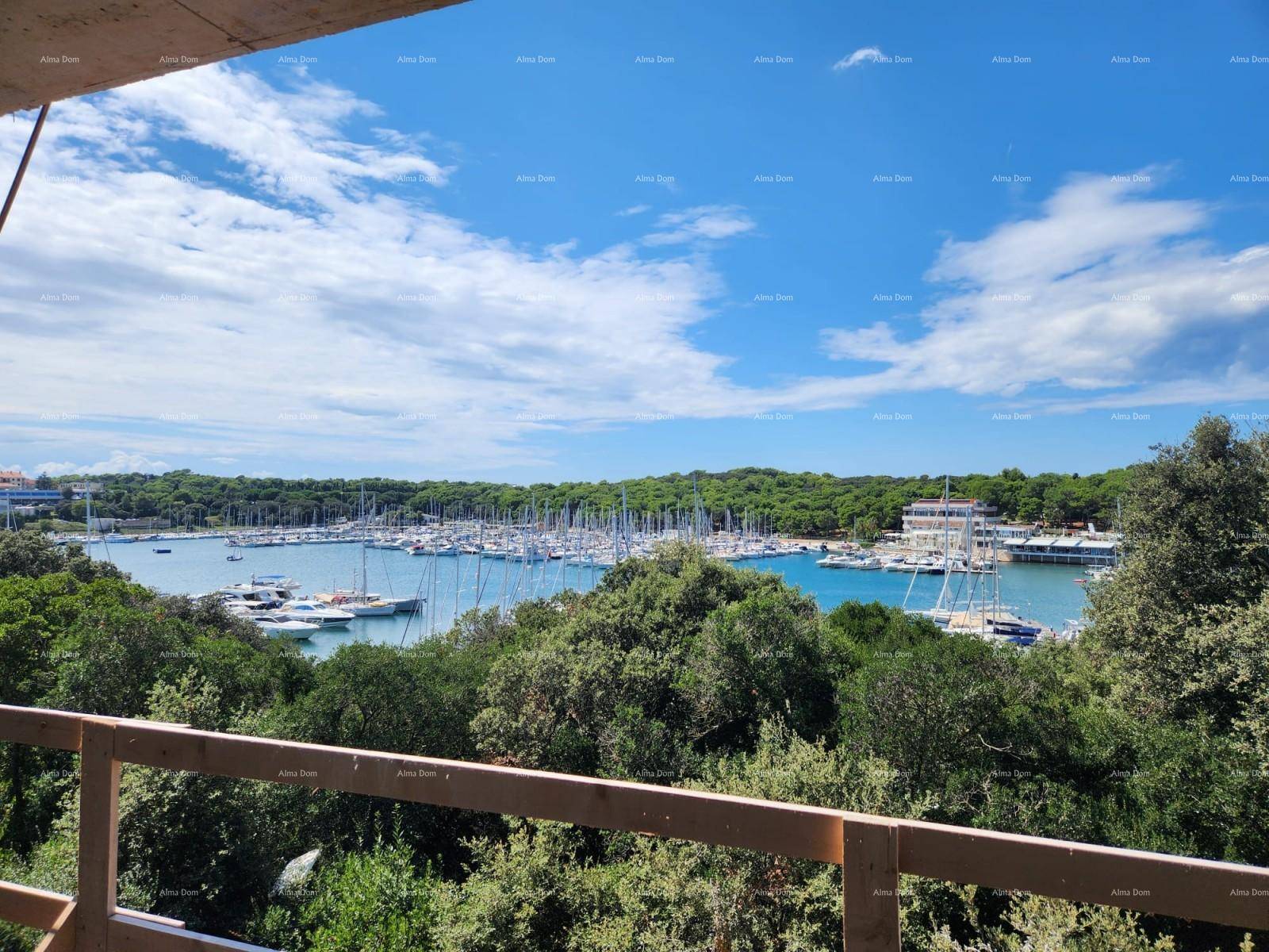 Panoramablick von einem unfertigen Balkon auf den Yachthafen, umgeben von üppiger grüner Vegetation.